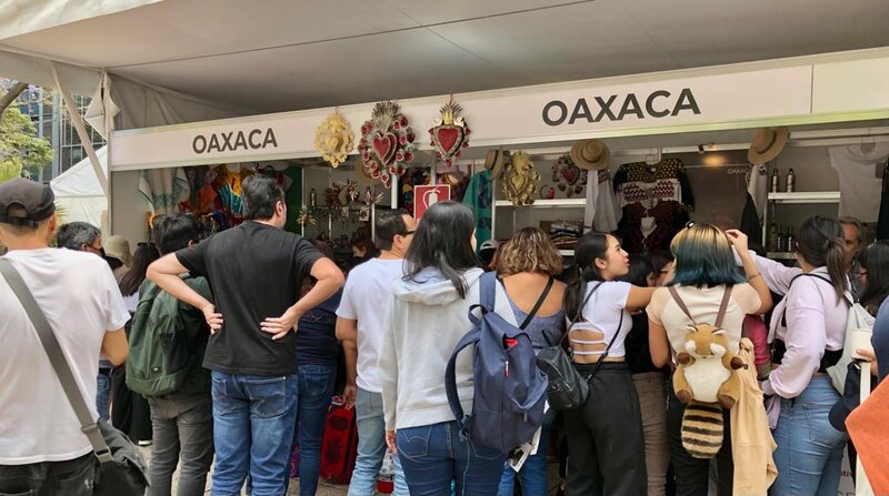 Un grupo de personas están comprando artesanías en un mercado en Oaxaca, México.