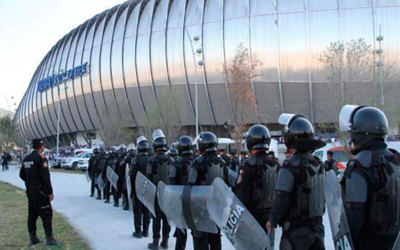 Policías antimotines mexicanos se forman frente a un estadio de fútbol.