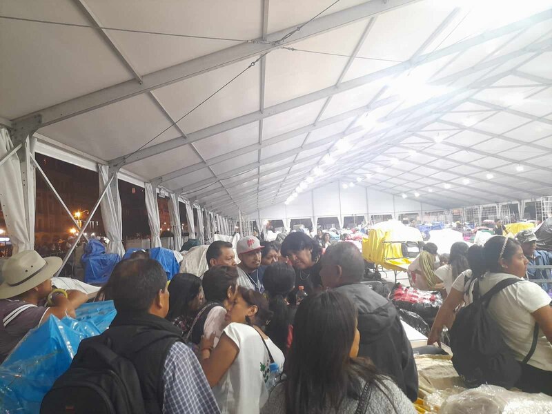 Un grupo de personas se reúne en una carpa.