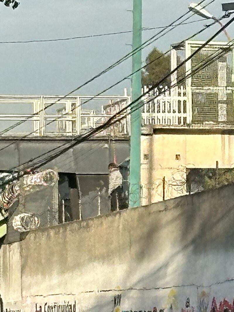 Un hombre camina por una pasarela en la ciudad.
