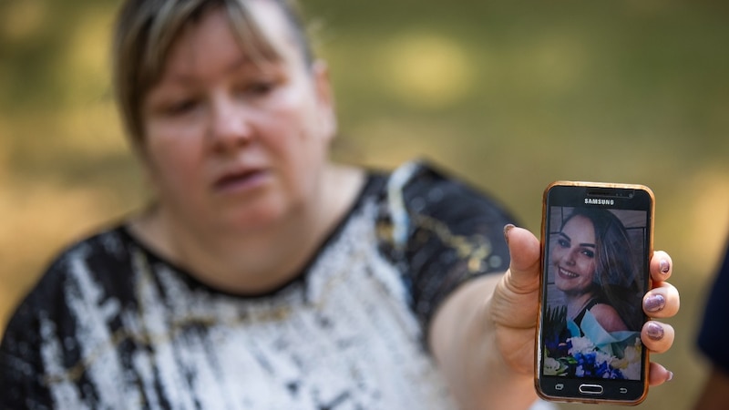 Madre sosteniendo una foto de su hija