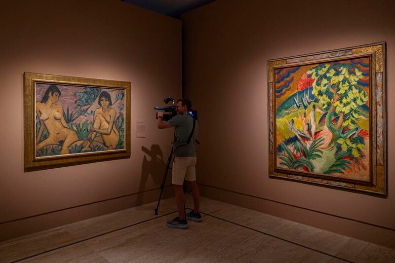 Un visitante del museo filma dos pinturas de desnudos femeninos.
