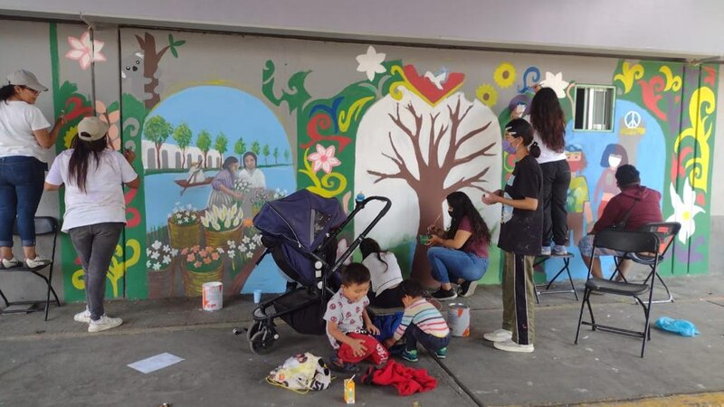 Mujeres pintando un mural en una pared