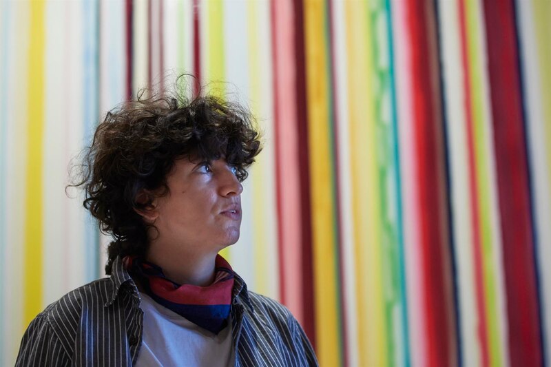 Mujer joven mirando un mural de arte abstracto