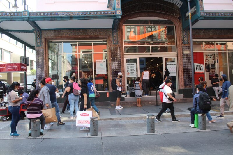 Larga fila de personas esperando para entrar a una tienda Nike