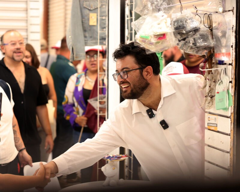 Político estrechando la mano de un hombre en un mercado.