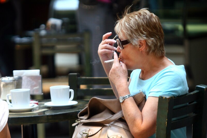 Mujer fumando en una cafetería