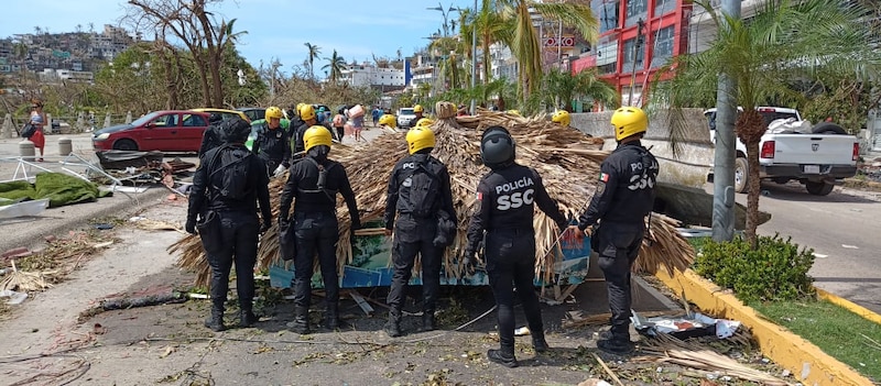 Policías retiran escombros tras el paso del huracán "Grace" en Quintana Roo