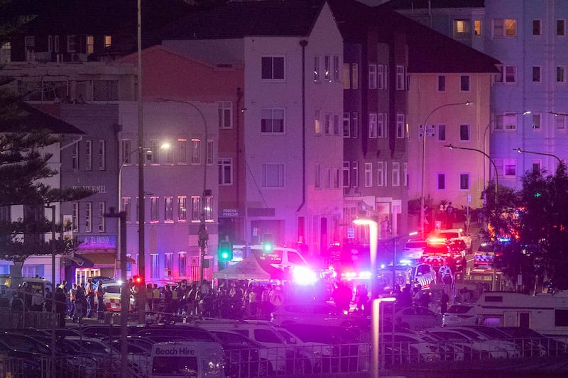 La policía y los servicios de emergencia evacúan la zona de la playa de Bondi en Sídney, Australia, donde este domingo al menos 10 personas han muerto,