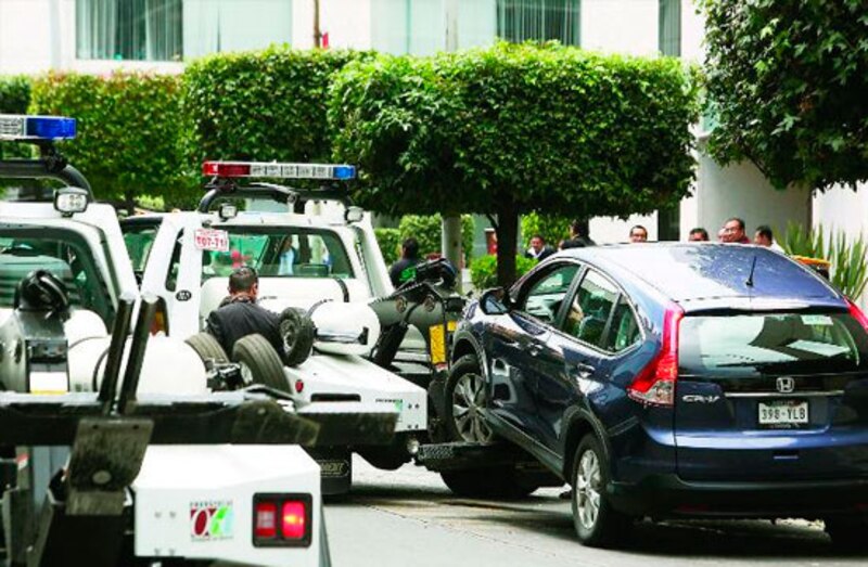 coche azul siendo remolcado por una grúa en la ciudad