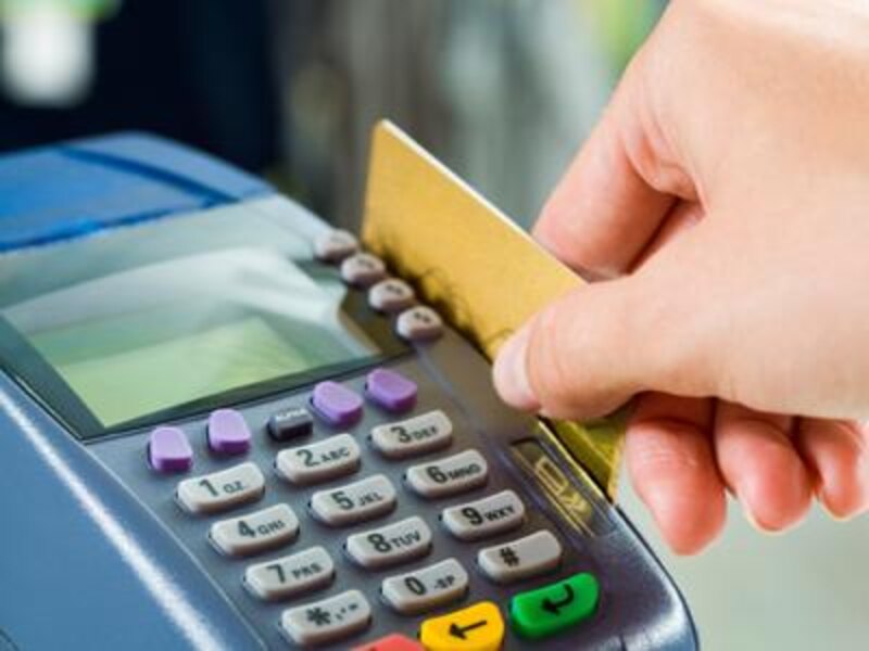 Mujer usando tarjeta de crédito en un datáfono