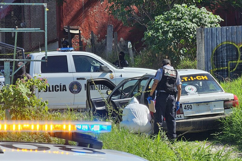 Forenses trabajando en la zona donde fueron hallados cuerpos sin vida al interior de un vehículo de transporte, en Chilpancingo