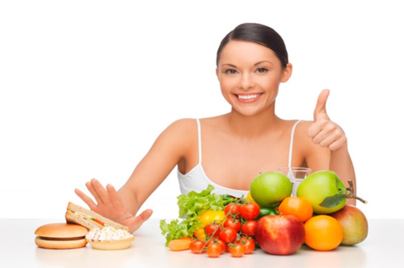 Mujer joven eligiendo entre comida saludable y no saludable