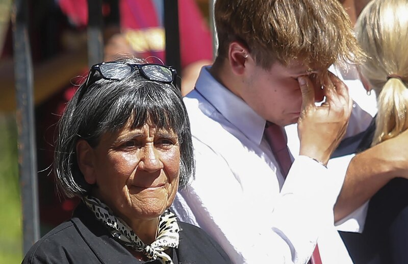 Madre e hijo lloran en un funeral
