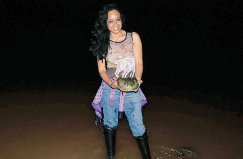 Mujer sosteniendo una tortuga en la playa