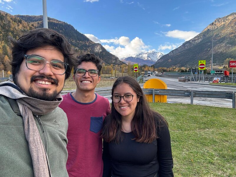 Tres amigos sonríen para una foto en los Alpes suizos.
