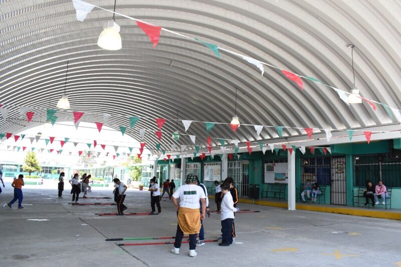 Estudiantes de primaria haciendo educación física en el patio de la escuela
