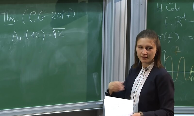 Profesora de matemáticas da una clase en la pizarra
