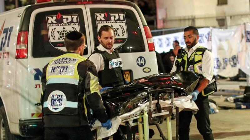 Rescatistas israelíes trasladan el cuerpo de una víctima en camilla