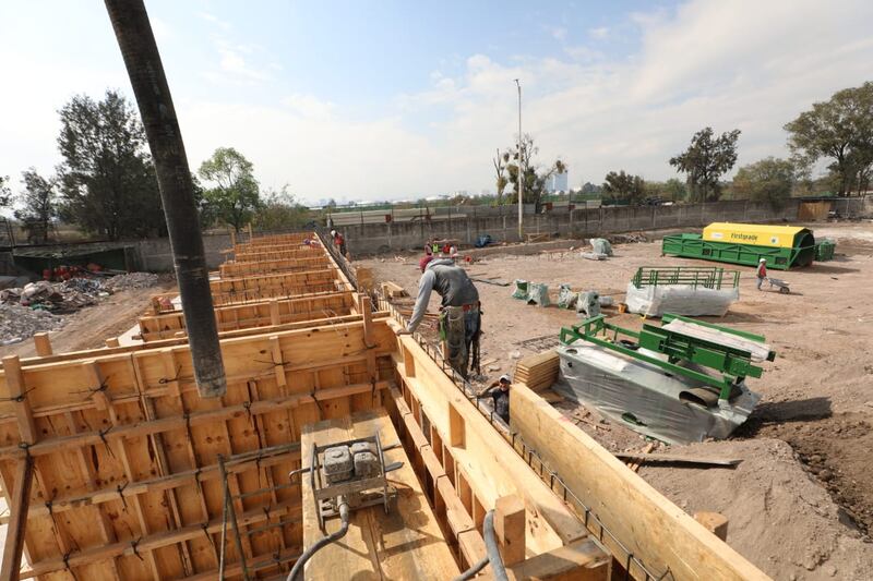 Obreros trabajan en la construcción de un muro de contención.