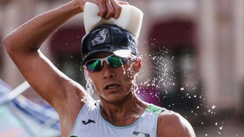 Atleta se refresca con agua durante una carrera