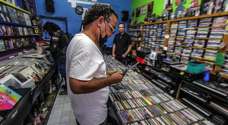 Un hombre busca discos en una tienda de discos.