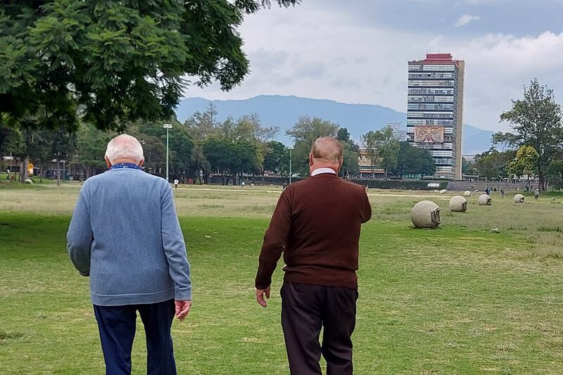 Dos hombres mayores caminan por un parque en la Ciudad de México
