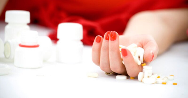 Mujer sosteniendo pastillas en la mano