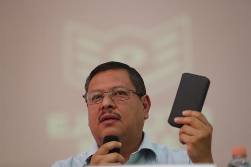 El presidente municipal de Zapopan, Pablo Lemus, muestra un teléfono celular durante una rueda de prensa.