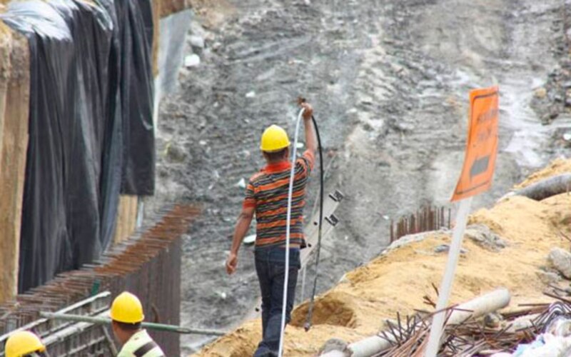 Obreros de la construcción trabajando en una zanja