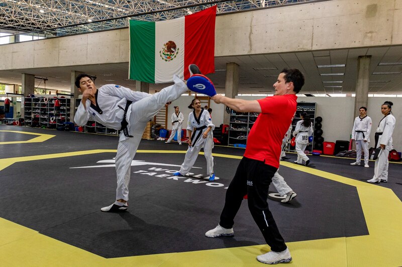 Un hombre y una mujer practican taekwondo.