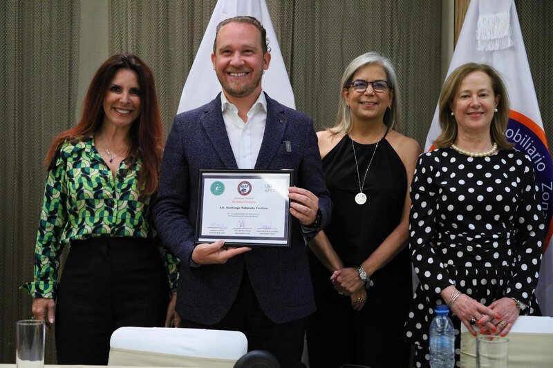El presidente de la Cámara de Comercio de Bogotá, Nicolás Uribe Rueda, entrega un reconocimiento a la presidenta de la Asociación Nacional de Empresarios de Colombia (ANDI), Bruce Mac Master.