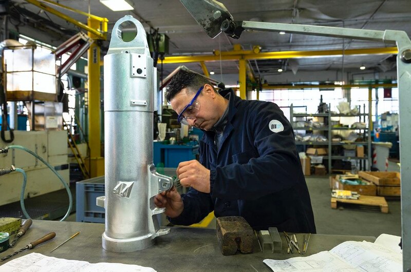 Un trabajador de una fábrica está trabajando en una pieza de metal