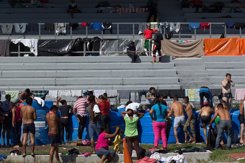 Migrantes se bañan en una piscina pública en Tijuana, México.