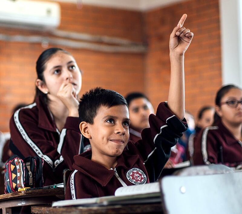 Niño indígena levanta la mano en clase