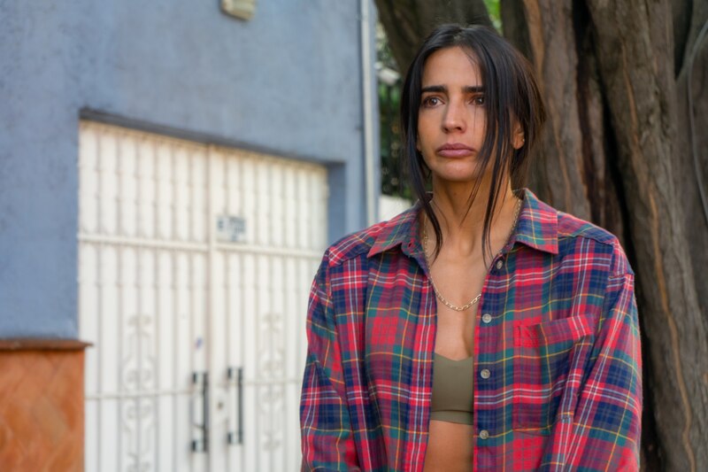 Mujer joven con camisa de franela roja y sujetador verde oliva