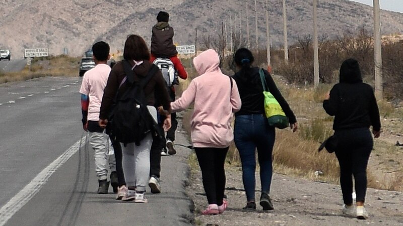 Familia migrante caminando por una carretera