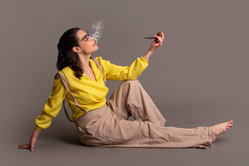 Mujer joven fumando en pipa