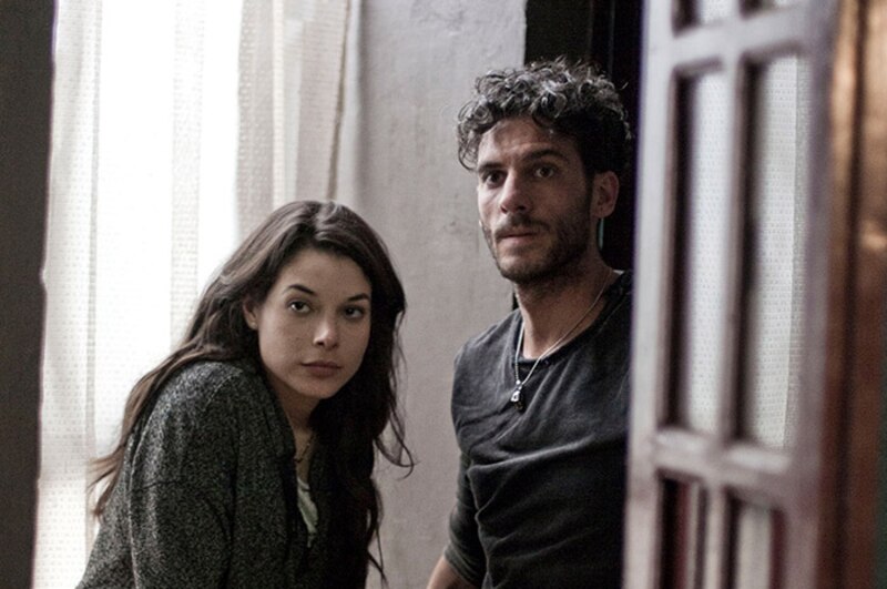 Una pareja joven mira por la ventana