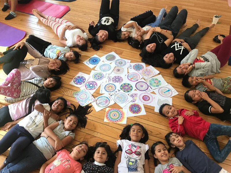 Niños en círculo haciendo mandalas