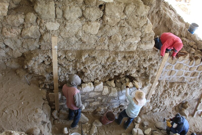 Trabajadores restaurando un muro de piedra