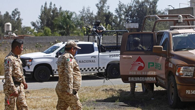 Soldados mexicanos resguardan un vehículo oficial.