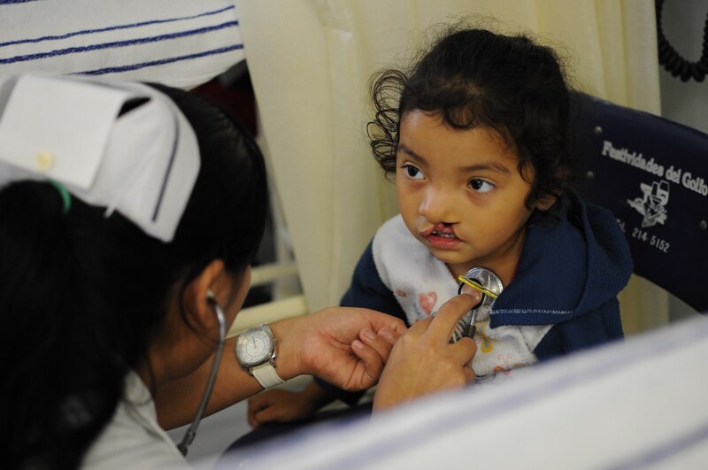 Doctora examinando a una niña con un estetoscopio