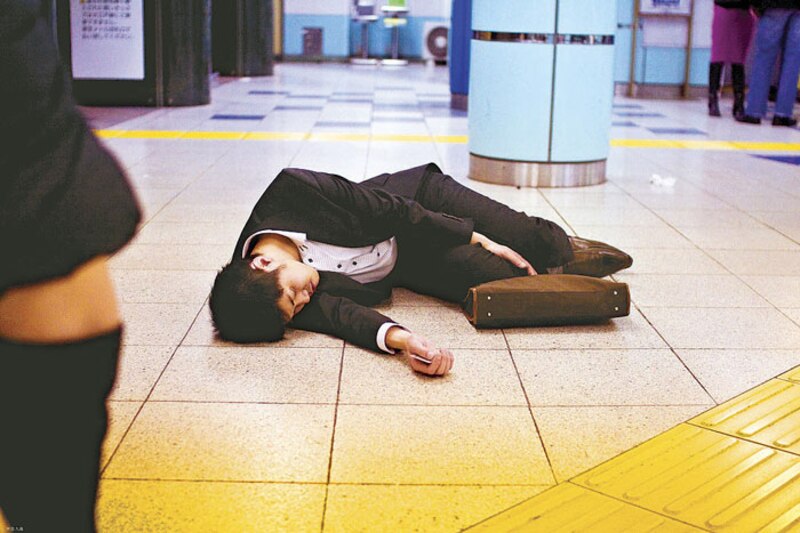 Un hombre dormido en el suelo de una estación de metro