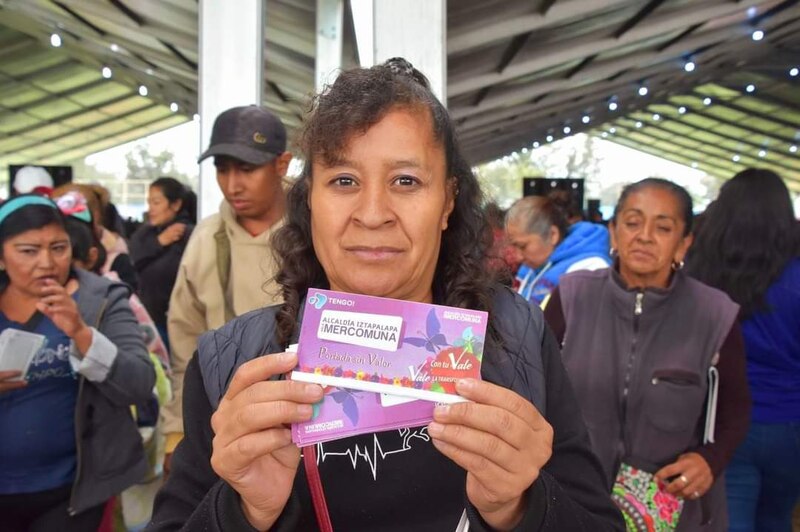 Mujer mexicana muestra su tarjeta de vacunación COVID-19