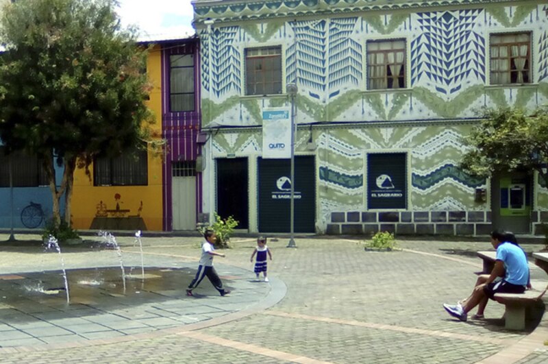 Niños jugando en una fuente en el centro de Quito