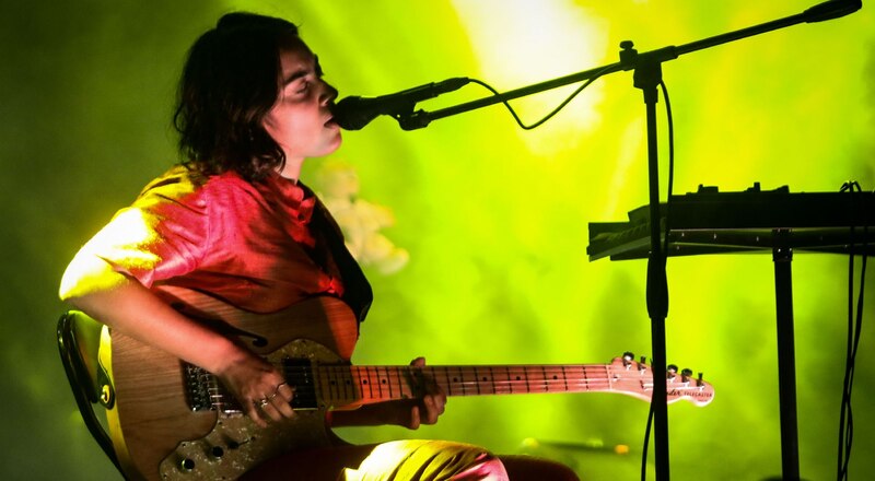 Cantante tocando la guitarra en un concierto