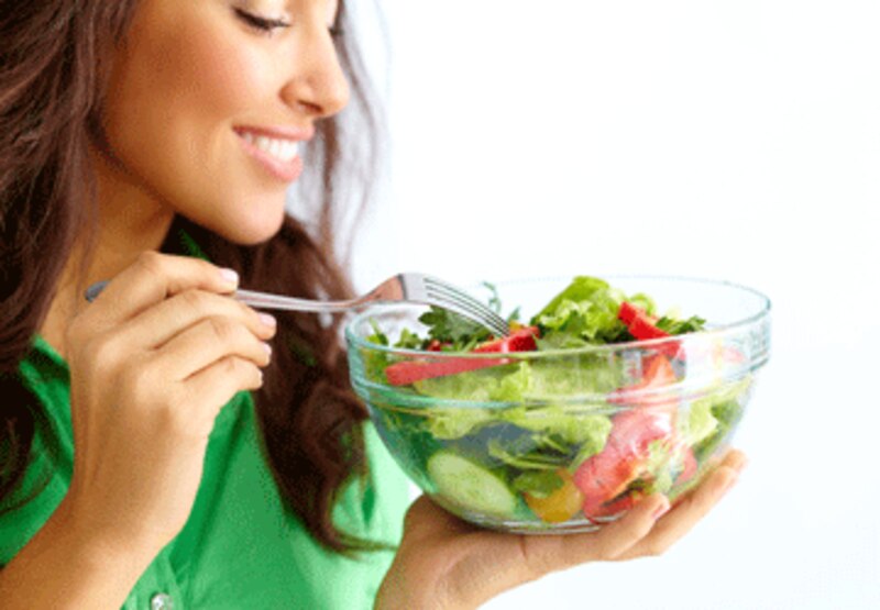 Mujer joven comiendo una ensalada saludable