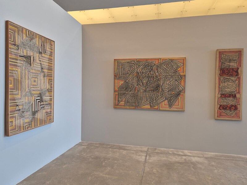 Tres pinturas abstractas en una galería de arte