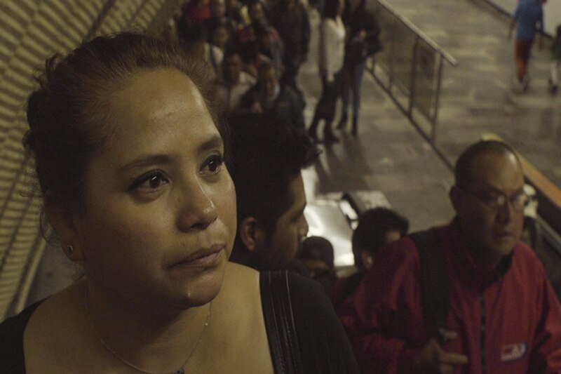 Mujer mirando hacia arriba en el metro